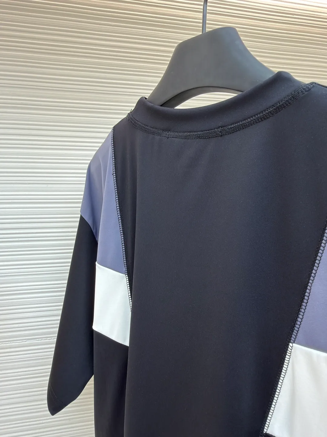 LOUIS VUITTON Spliced round neck jogging short-sleeved T-shirt ●Original version: purchased and developed by 8167 ●Item number: 1682020-A20 ●Fabric: cotton fabric ●Technology: made on positioning cutting machine ●Color: black, gray and white ●Type: fitted version ●Weight: about 295 grams ●Size: S-M-L-XL ●Description: This LOUIS VUITTON The FW25 jogging short-sleeved T-shirt is made of high-elastic technical knitted fabric (presumably a blend of polyester fiber and spandex). It has been treated with directional stretching technology and has both breathability and sports extensibility. The body of the garment adopts color-blocking insert technology: black, gray, and white panels are spliced ​​diagonally in a V-shape, and the edges are processed with "boneless overlocking" to make the seams smooth and smooth. The "LV" logo on the chest uses a silicone embossing + embroidery composite process: first outline the outline with embroidery thread of the same color, and then cover it with a matte silicone layer, which not only ensures the three-dimensionality of the logo, but also prevents it from falling off after washing. The neckline is double-layered ribbed and has built-in elastic webbing for reinforcement, making it less likely to deform after long-term wear. The overall shape is sporty and slim-fitting, and the arc of the cut piece has been ergonomically optimized, making it suitable for light sports such as jogging. The overall wiring is straight and delicate, the fabric is comfortable and soft, and the color is consistent without color difference. It can be matched with the same style to create a fashionable look and control various occasions. Customized accessories, complete with three standards, same style for men and women!